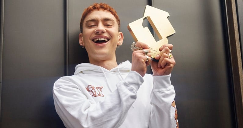 Olly Alexander with a custom gold trophy